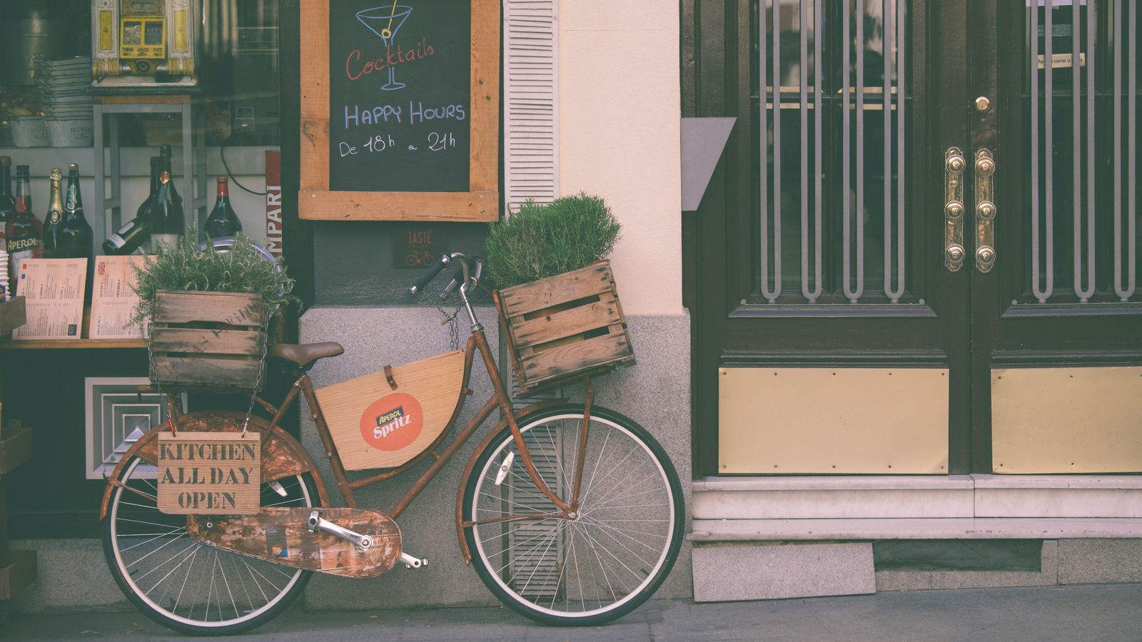 Devanture d’un bar, un vélo garé contre la façade