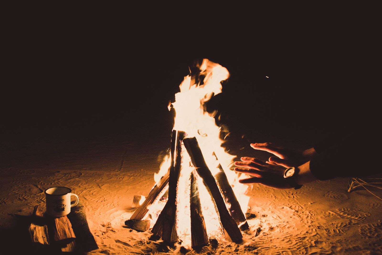 Un feu de camp, la nuit, sur le sable